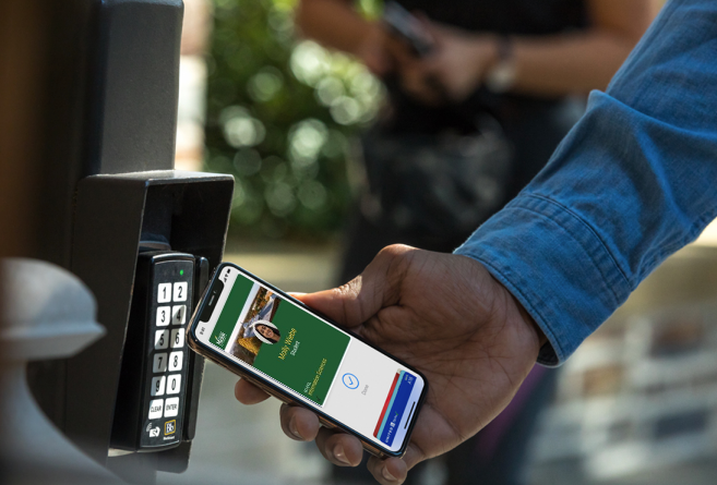 A person holding their phone next to a door lock with the Mason Mobile ID